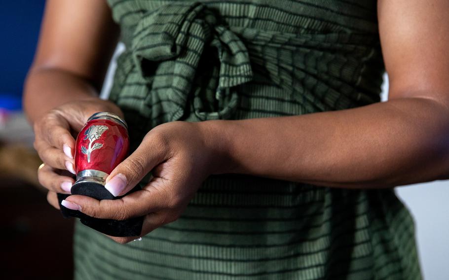 Petitfrere holds an urn containing the ashes of her stillborn son, Primas.