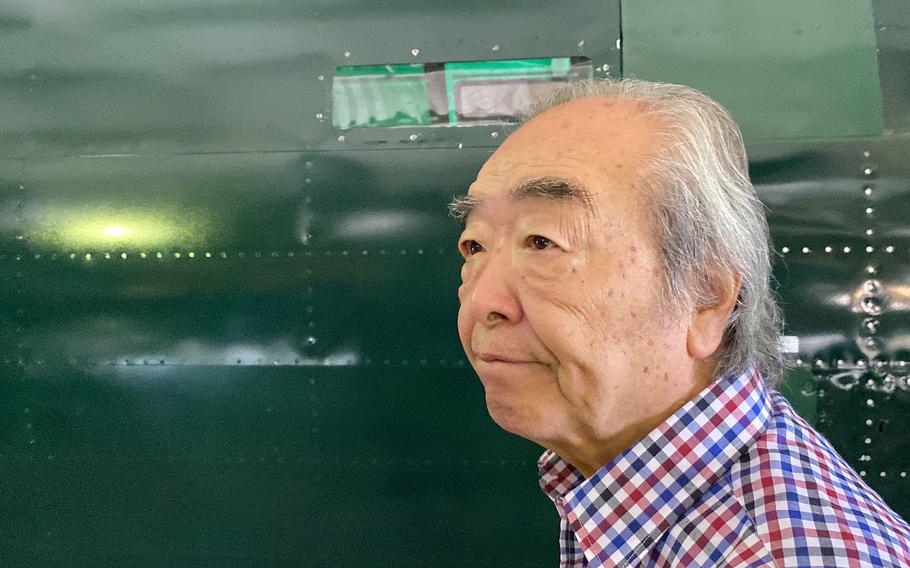 Nobuo Harada, 85, stands next to his restored Mitsubishi G4M bomber at the Kawaguchiko Zero Fighter Museum near Mount Fuji, Japan, Sunday, July 31, 2022.