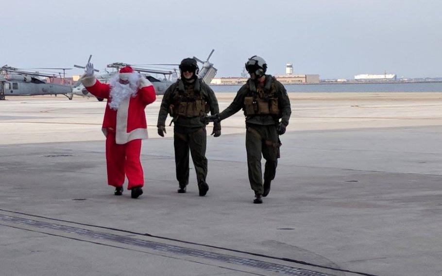 Santa waves after landing at Naval Station Norfolk after a flight on a MH-60S Knighthawk helicopter flown by Navy pilots from Helicopter Sea Combat Squadron 2, also known as the “Fleet Angels,” on Dec. 9, 2017. 
