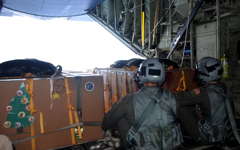 Airmen aboard a C-130J Super Hercules prepare to parachute crates filled with donated Operation Christmas Drop supplies to remote islanders in the Federated States of Micronesia, Wednesday, Dec. 7, 2022.