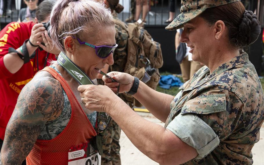 Women’s champion Bonnie Keating receives her medal after winning the 48th Marine Corps Marathon on Sunday, Oct. 29, 2023, in Arlington, Va.