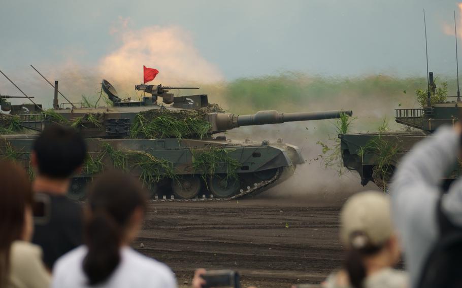 Japan Ground Self-Defense Force tanks perform live-fire drills in front of spectators.