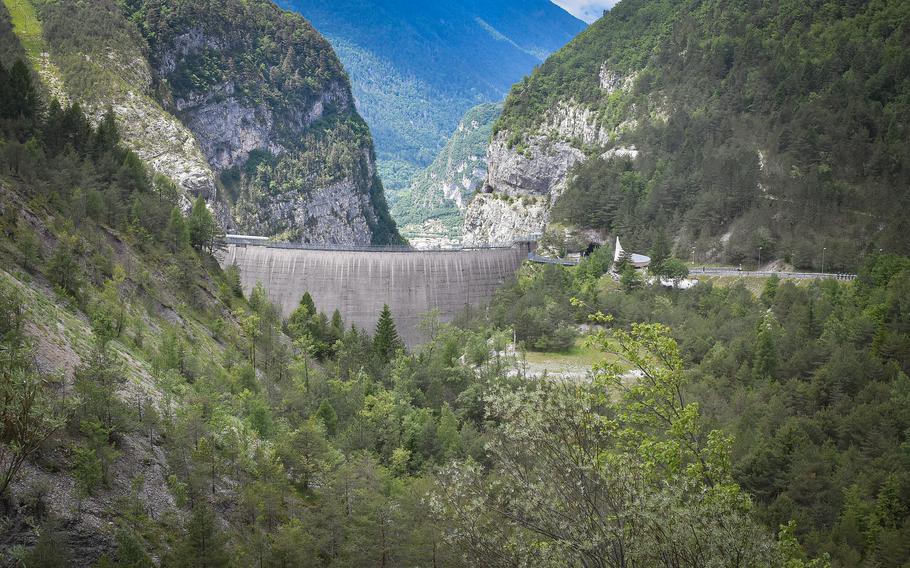 The Vajont Dam in northeastern Italy is dwarfed by the mountains surrounding it. Part of the nearby village of Longarone, which was rebuilt after a devastating wave flowed over the dam on the night of Oct. 9, 1963, can be seen in the background.