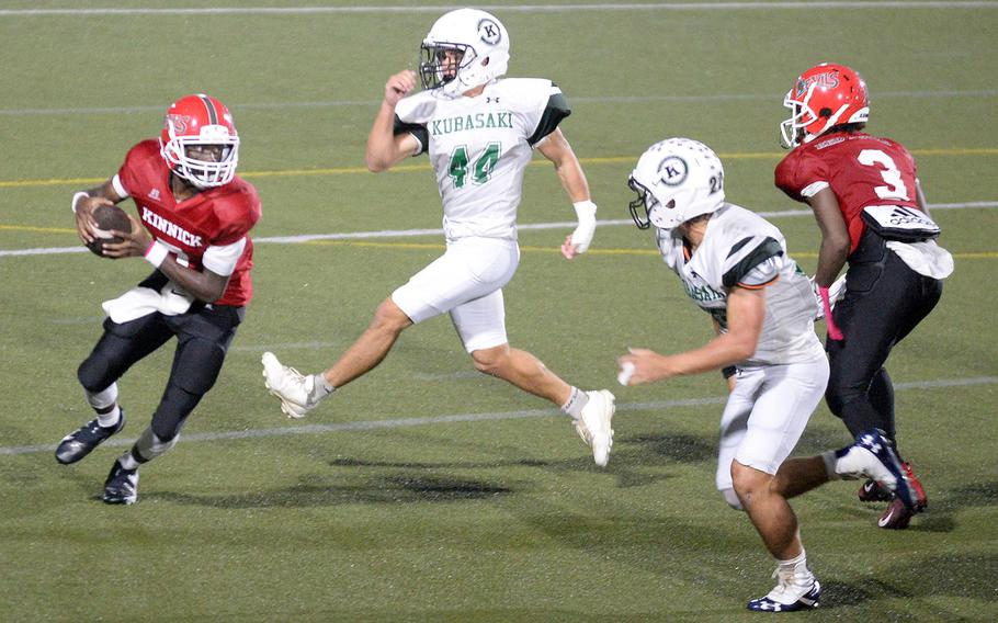 Nile C. Kinnick quarterback Josiah Chambers tries to elude Kubasaki's Hayden Potter and Kaito Moore.