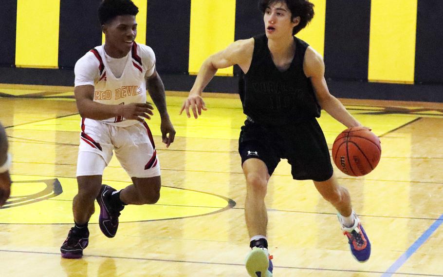 Kubasaki's Troy Harris dribbles against Kinnick's Xavier Wright. The Red Devils won the quarterfinal game 71-40.