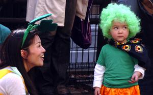 Tokyo, Japan, Mar. 16, 2008: A young Japanese spectator at the 17th annual Tokyo St. Patrick's Day Parade clad in orange dress and green wig looks suspiciously at a photographer while her mother tries to talk her into letting him snap her image.   

META TAGS: Japan; St. Patrick's Day; Irish-American Heritage Month; festival