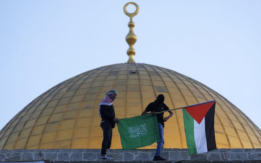 Palestinian and Hamas flags are carried next to the Dome of the Rock Mosque in the Old City of Jerusalem, May 2, 2022. The Palestinian militant group Hamas on Thursday, Sept. 22, threatened hostile actions against Israel over what it called “violations against Jerusalem and the Al-Aqsa Mosque.”