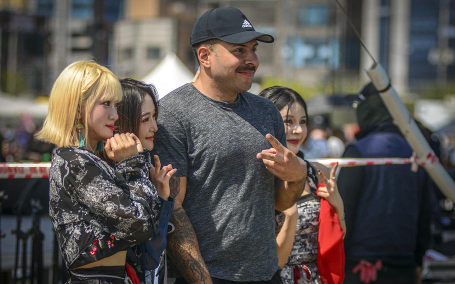 Members of the K-pop group ICU pose with a fan during Spring Fest at Camp Humphreys, South Korea, May 18, 2024. 