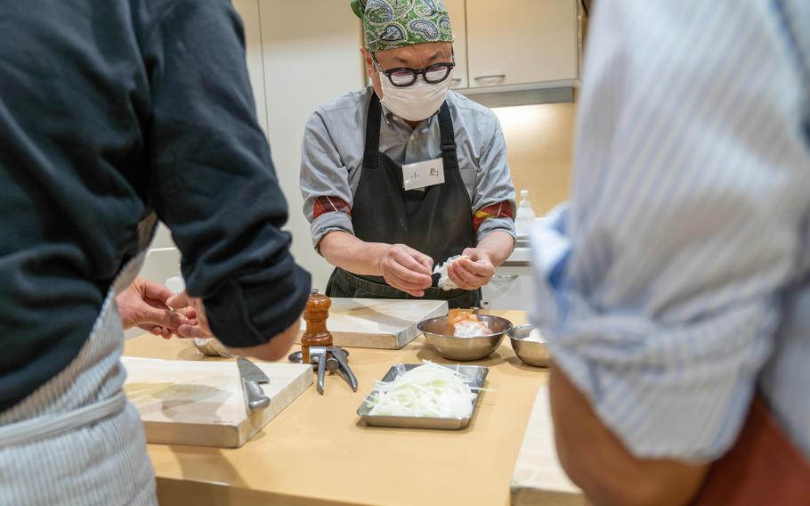 Students work as a team in the Better Home cooking class for men in Tokyo. 