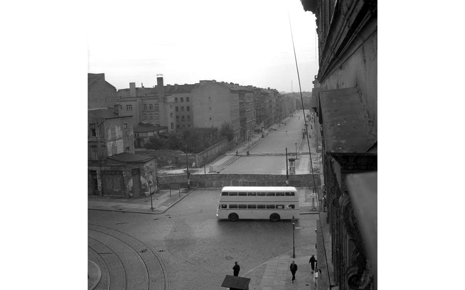 A West Berlin bus drives by the Wall that blocks off part of the intersection.