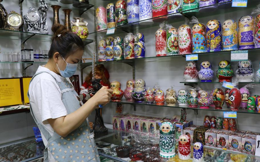 A shopkeeper in Heihe, China, near the border with Russia, arranges souvenirs on June 27, 2022. The tourist town has been hurt by pandemic restrictions against international visitors. 