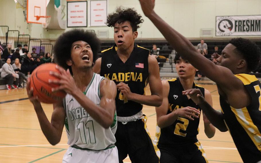 Kubasaki's Zyiere Paul tries to shoot against Kadena defenders Cory Tripp, Ethan Camagian and Javontay Vickers during Thursday's Okinawa boys basketball game. The Panthers won 61-44.