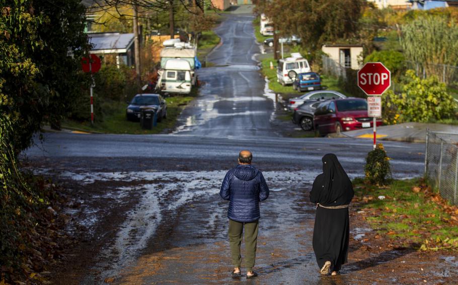 Afghan refugee Abdul Matin Qadiri, 46, left, and his wife walk to the grocery store on Saturday, Nov. 6, 2021 in Seattle. He is eager to get a drivers licence, a job, a can and also eager for his children to attend school. Qadiri and his wife and 4 children are Afghan refugees and they are currently staying in the rental home owned by Dr. Thuy Do and her husband Jesse Robbins.