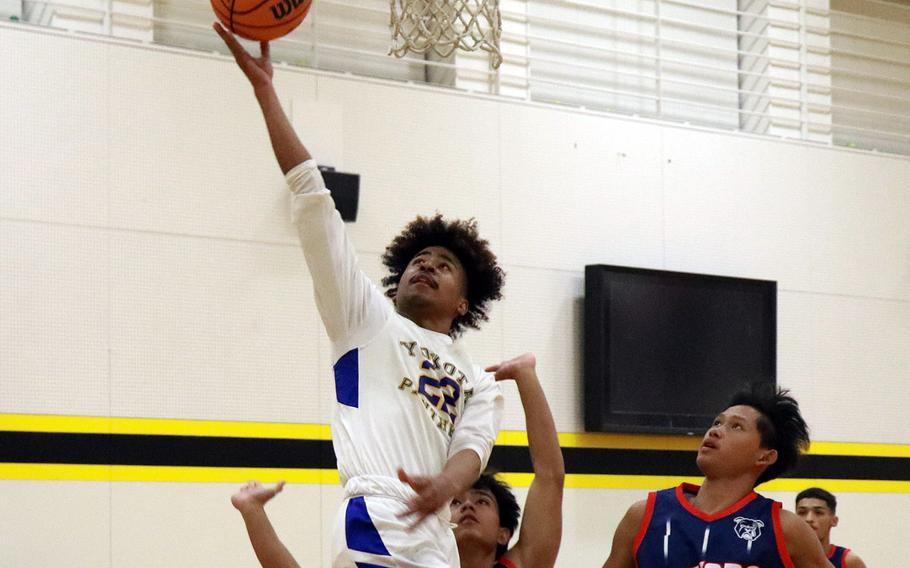 Yokota’s Marcus Woods skies for a rebound against Okkodo in the third-place game in the 5th American School In Japan Kanto Classic basketball tournament. 