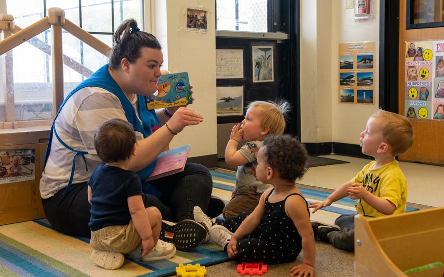 A child care provider at a development center reads a story to children April 11, 2023, at McConnell Air Force Base, Kan. 