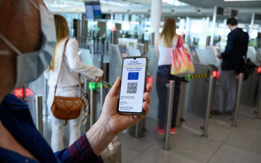 A traveler presents his European Union digital COVID certificate at a Brussels airport, April 6, 2021. U.S. military bases in Italy are enforcing a new law requiring foreign national workers to have a printed or digital green pass to qualify for continued employment.