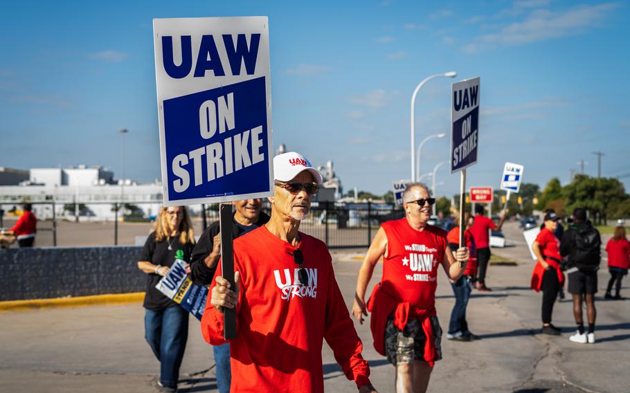 People walk a United Auto Workers picket line at the Ford Michigan Assembly Plant on Friday in Wayne, Mich. The union is striking against Ford, General Motors and Stellantis. 