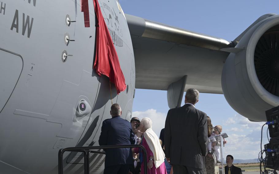 U.S. Air Force Gen Mike Minihan, comander of Air Mobility Command, left, helps unveil a C-17 Globemaster III that was renamed to "Spirit of the Candy Bomber" in Provo, Utah, May 20, 2022, to honor Gail Halvorsen of Berlin Airlift fame.