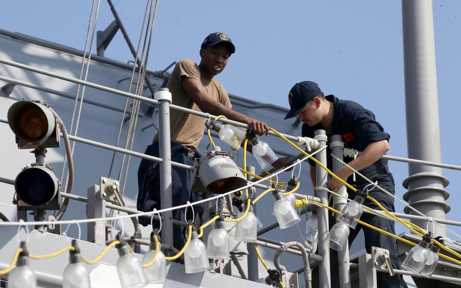 Sailors work aboard the amphibious assault ship USS America while docked at Manila's South Harbor, Tuesday, March 21, 2023.