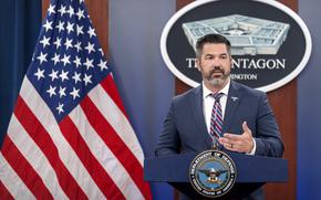 Parnell stands at a lectern with the American flag and a Pentagon sign behind him.