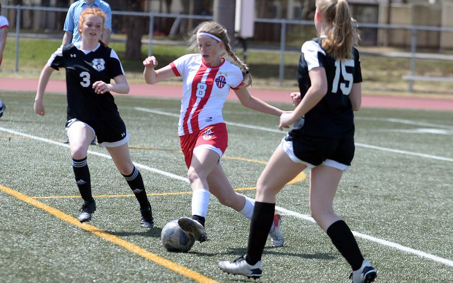 Nile C. Kinnick's Bree Withers dribbles and slices between Zama's Avery Pilch and Sophie Jacklyn during Saturday's DODEA-Japan soccer match. The Red Devils won 2-0.