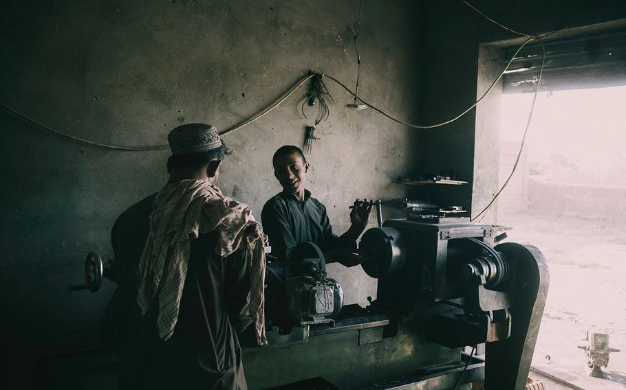 Hajji Trojan Musafir’s son, Haji Torjaan, works in the family’s auto repair shop in Marja, where business is slower than ever, on June 13, 2022.