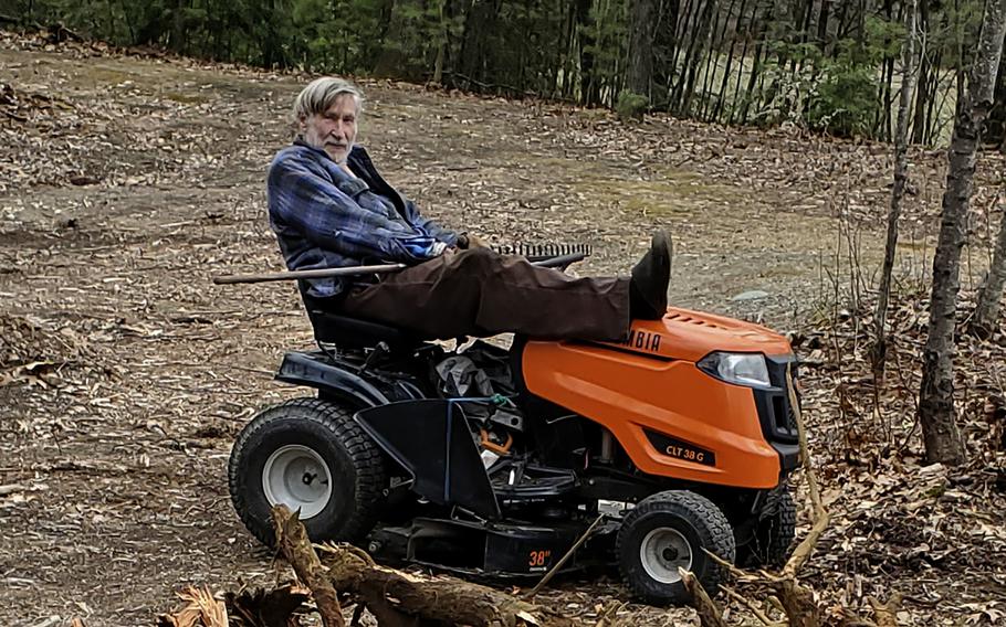 In this photo provided by Ed Smith, Geoffrey Holt rests his leg on top of his riding mower in Hinsdale, N.H., on April 4, 2020. Holt left the town of Hinsdale nearly $4 million when he died last June.