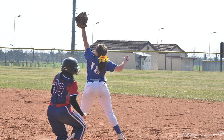 Sigonella's Hannah Gildea stretches high to handle a throw to first that got there before Aviano baserunner Edith Hernandez did on Saturday, March 18, 2023.