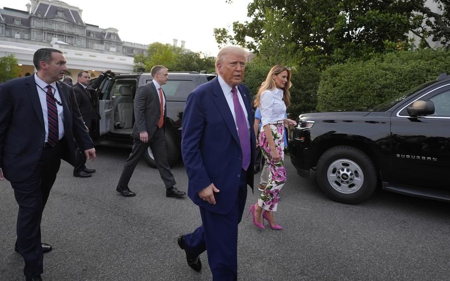 President Donald Trump and first lady Melania Trump walk after greeting guests during the congressional picnic on the South Lawn of the White House.