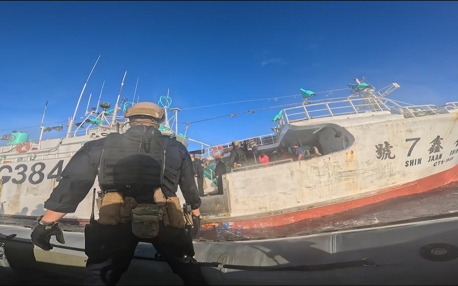 A service member approaches a fishing vessel