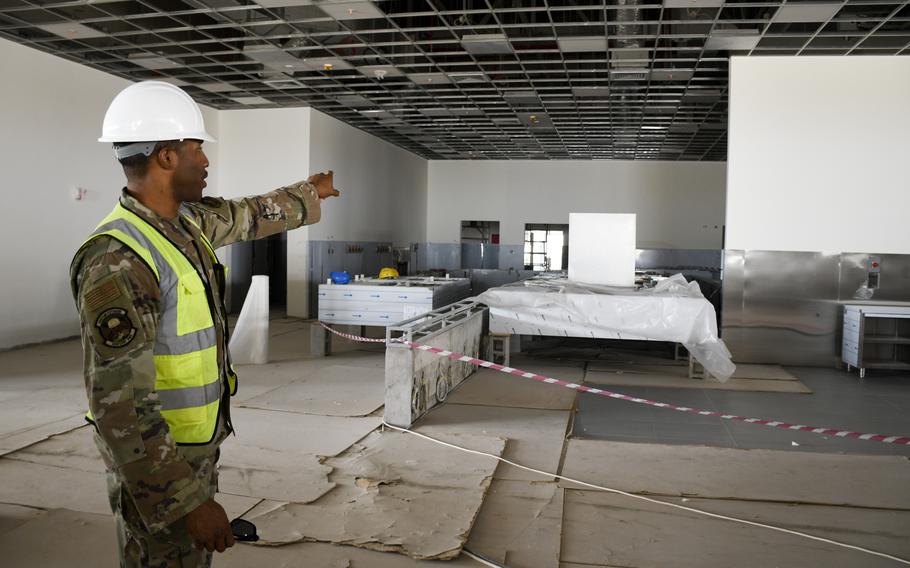 Maj. Samuel Richardson, construction management chief at the Ninth Air Force (Air Forces Central) program management office, shows where the serving areas will be inside a dining facility under construction at Al Udeid Air Base, Qatar, April 22, 2022.