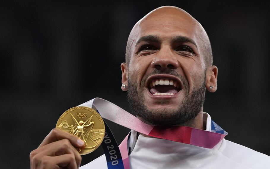 Lamont Marcell Jacobs of Italy, the surprise winner of the Olympic 100 meters, shows off his gold medal on Monday, Aug. 2, 2021, in Tokyo. 