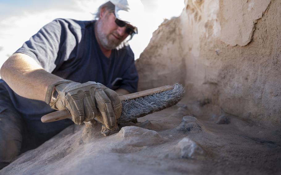 Matthew Cuba, cultural resource manager for the 49th Civil Engineer Squadron, brushes off the remnants of a recently uncovered Paleo-Archaic hearth at Holloman Air Force Base, New Mexico, on March 7, 2024.