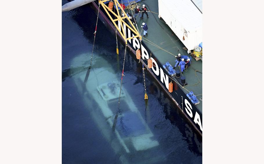 The Kazu I sightseeing boat is raised from the sea by a salvage vessel in May, 2022.