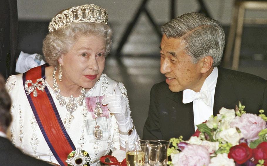 The then Emperor and Queen Elizabeth II chat at a dinner banquet in London during his visit to Britain in May 1998. 