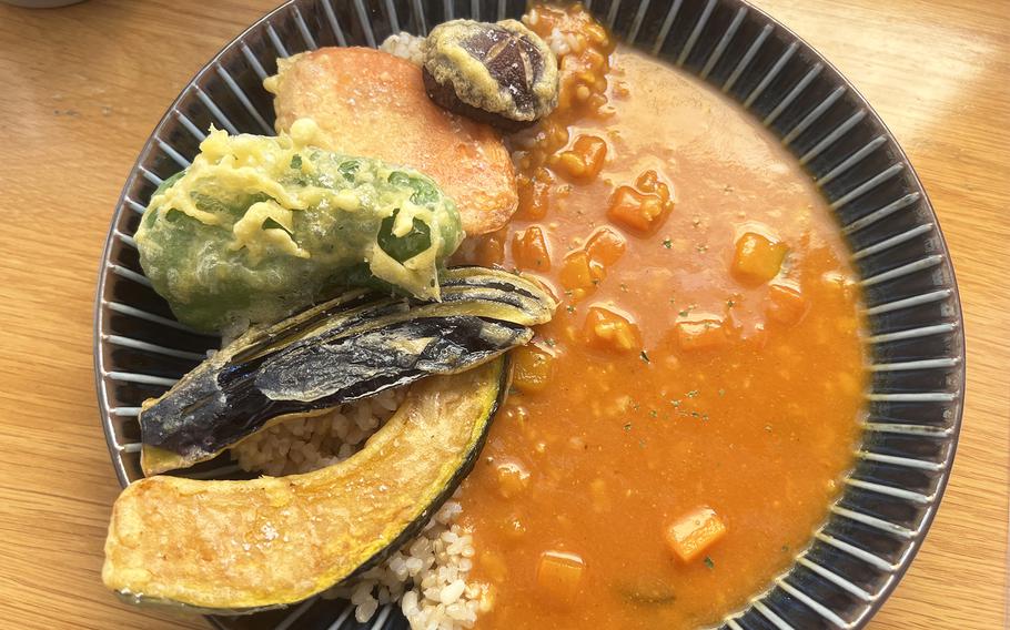 Tempura topping curry, a  curry of fresh vegetables topped with vegetable tempura with multigrain rice at Marugoto Vegan Dining Asakusa in Tokyo. 
