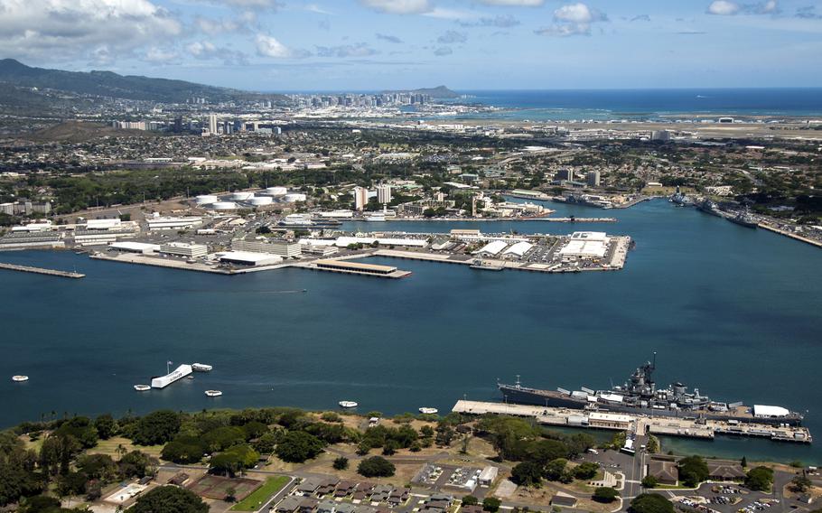 An aerial view of the USS Arizona and Battleship Missouri Memorials at Ford Island, Joint Base Pearl Harbor-Hickam, Hawaii. Diamond Head, Honolulu and Waikiki are in the distance.