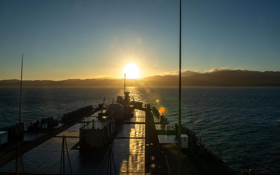 The USS Blue Ridge arrives in Wellington, New Zealand, as the sun sets in the background.