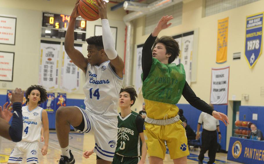 Osan's Jaylon Grant snags a rebound in front of Daegu's Beckham Clites during Tuesday's 71-43 win by the Cougars.