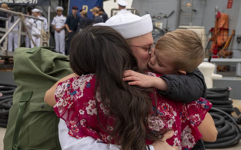 A sailor assigned to the destroyer USS Mitscher embraces his family after the ship's return to Naval Station Norfolk, Va., April 16, 2022. Mitscher and USS The Sullivans deployed to Europe earlier this year as tensions rose in Ukraine. They returned to their U.S.-based homeports in the last few days, officials said.