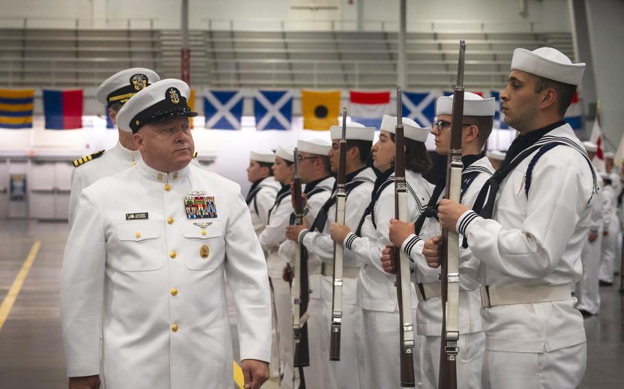 A high-ranking sailor walks past a formation of junior sailors.