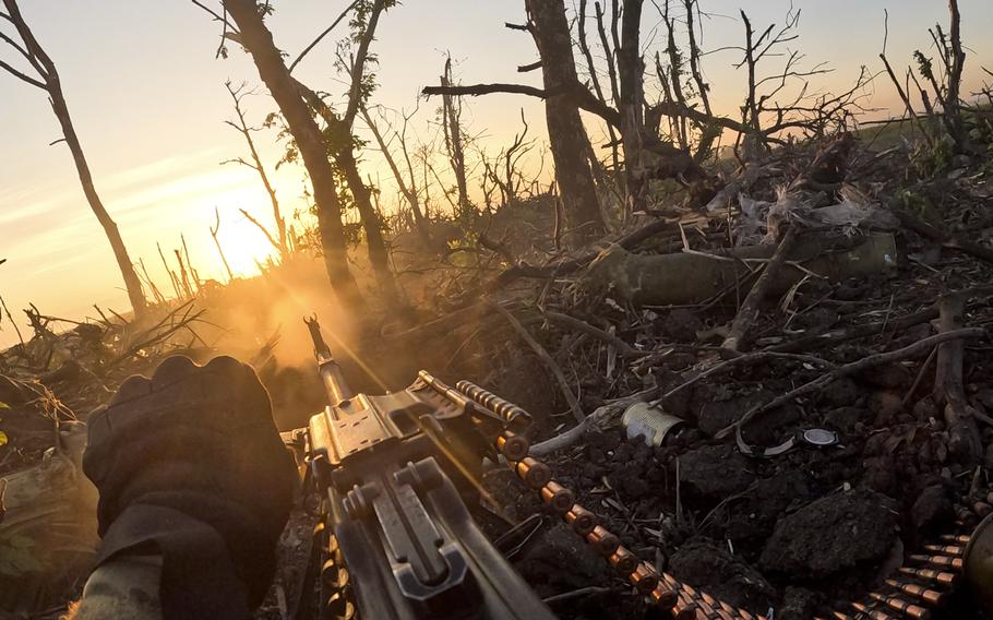 In this image taken from a video released by the 3rd Assault Brigade, a Ukrainian serviceman fires a machine gun towards Russian positions near Andriivka, Donetsk region, Ukraine, Aug. 27, 2023.