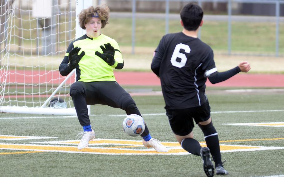 Zama’s Michael Gough drives the ball at Robert D. Edgren keeper Cole Donnelly during Saturday’s DODEA-Japan boys soccer match. The Trojans won 4-0.