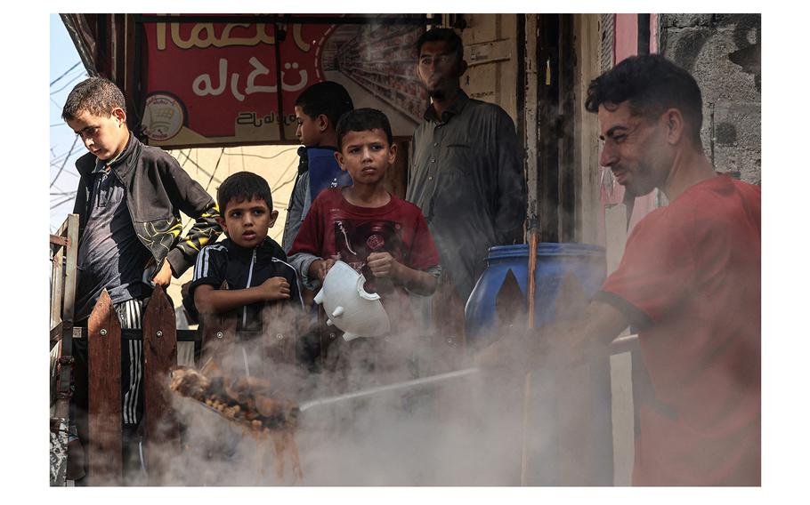 Palestinian children queue to receive a portion of food at a makeshift charity kitchen in Rafah in the southern Gaza Strip on Nov. 8, 2023. 