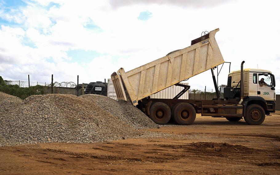 A dump truck unloads gravel.