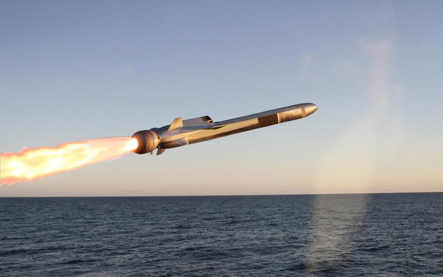 A missile is fired over water.