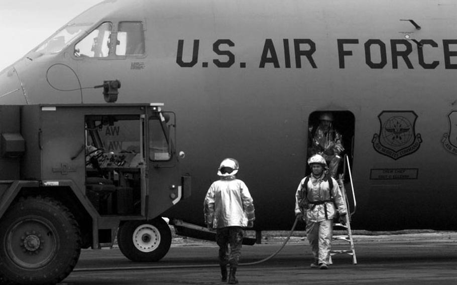 Taszar AB, Hungary, January, 1996: Firefighters inspect an Air Force cargo plane after a fire ignited from a car battery during offloading procedures.  