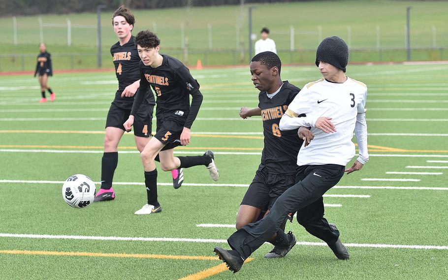 Alconbury midfielder M.J. Hash hits a pass in the box as Sentinel midfielder Xavian Appiah defends during a March 16, 2024, game at Spangdahlem High School in Spangdahlem, Germany.