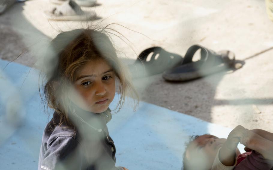 A young girl forced to flee her home following a Taliban advance sits at a park in Afghanistan on Friday, Aug. 13, 2021. 