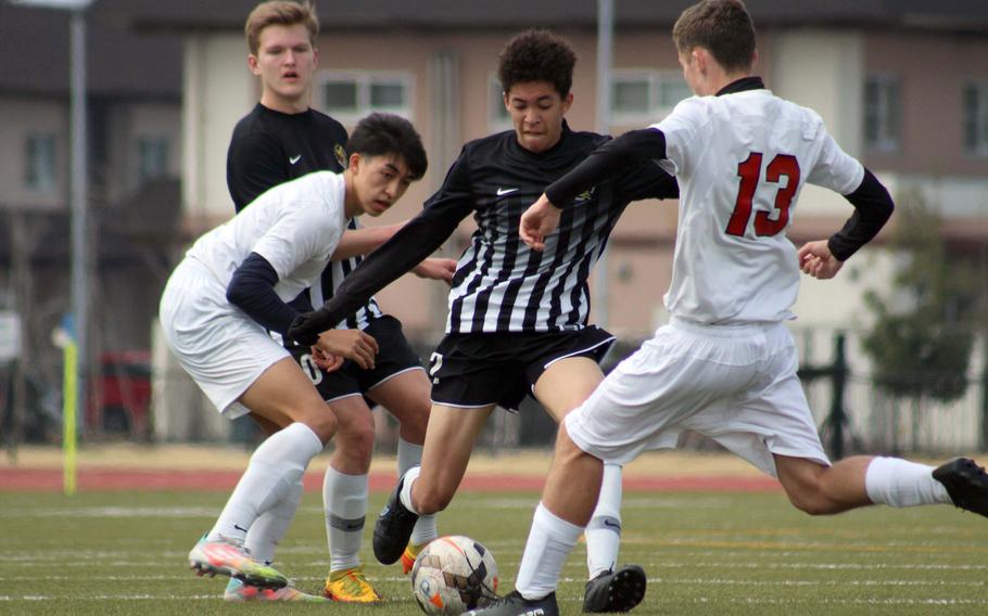 Matthew C. Perry's Billy Henry tries to play the ball between E.J. King's Kaito Bergman and Kai Sperl during Saturday's DODEA-Japan soccer match. The Samurai won 4-2.